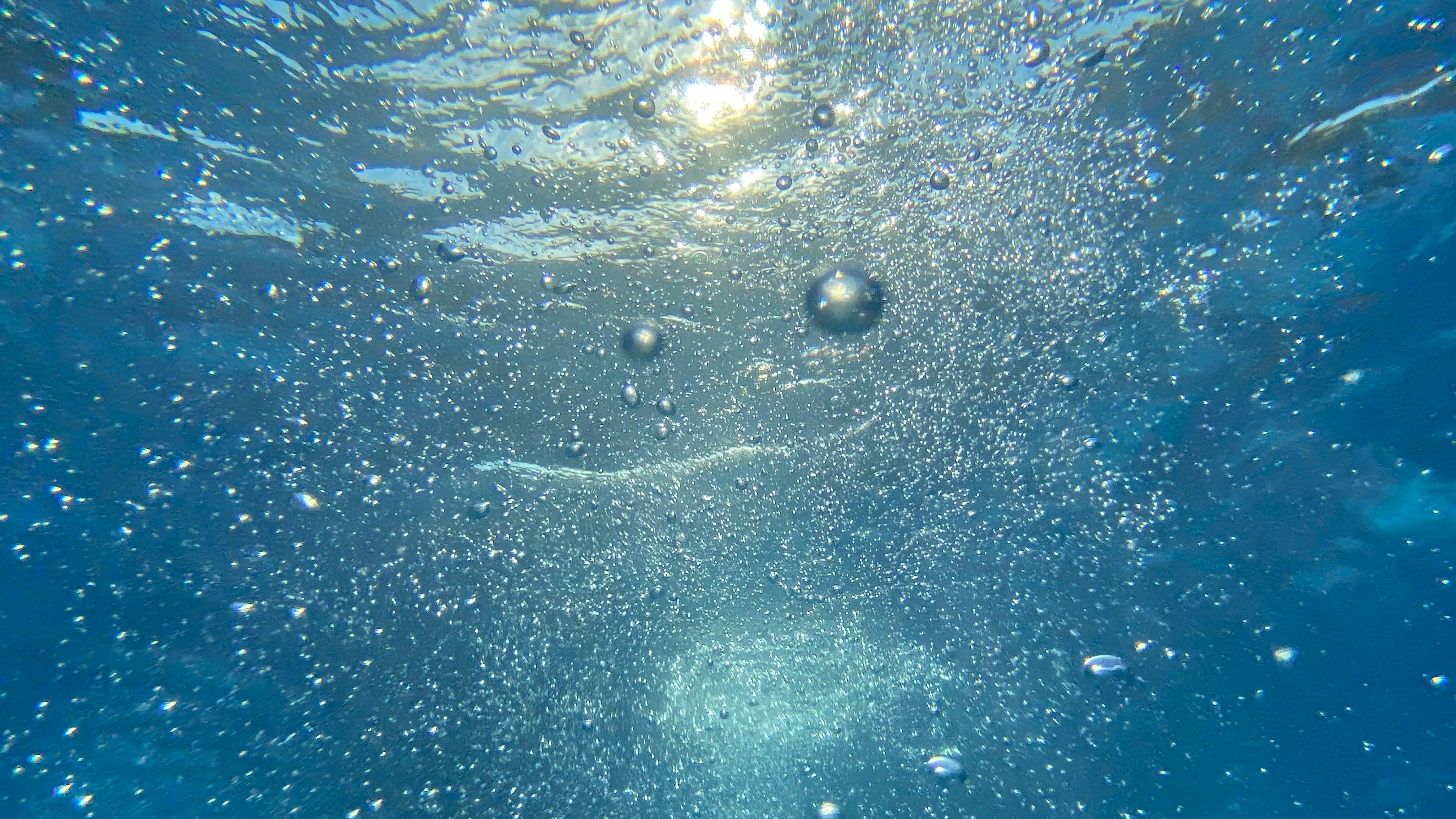 Bubbles rising in blue thermal mineral water